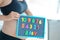 Young expectant mother with letter blocks spelling baby on magnetic blackboard