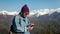 Young explorer bearded traveller man with backpack using compass or smartphone in snow mountains.