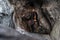 Young explorer in black sportswear in a cave with climbing equipment ready for action