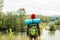 Young explorer standing on the bank of river in front of a fairy tale landscape