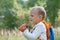 Young explorer watching with binoculars of birds in the high grass