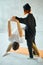 Young extraordinary female yoga teacher helping man student stretching indoor.