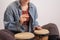 Young faceless Caucasian woman playing small ethnic drums