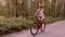 Young fair-skinned woman rides a bike through the forest