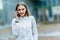 Young famale calling on a smartphone. Attractive businesswoman talking by phone. Office building Background. Technology