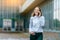 Young famale calling on a smartphone. Attractive businesswoman talking by phone. Office building Background. Technology