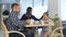 Young family in casual clothes drinking tea in cafe, talking and relaxing together.