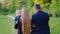 Young family with a child is walking in the park, rear view. A young baby boy looks at the camera. Healthy lifestyle