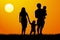 A young family with children silhouette at sunset
