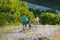 A young family consisting of mom, dad and child are walking down the stones from the mountain