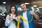 Young family couple handsome man and beautiful brunette woman holding charging cable for electric car , looking happy and excited