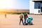 Young family couple with mom and dad are walking outdoors with a baby stroller of blue color in which the newborn child in a large