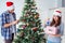 The young family decorating christmas tree on happy occasion