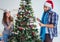 Young family decorating christmas tree on happy occasion