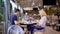 A young family dines at a restaurant, a woman is photographed by her husband, who drinks tea, their child drinks a