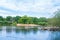 Young family enjoys use of row boats on small lake in scenic in Epping Forest with swans and ducks on bank