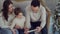 Young family excitedly watching tablet sitting on the sofa