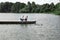 Young family feeds wild ducks sitting on a pier by the lake