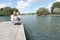 Young family feeds wild ducks sitting on a pier by the lake