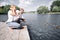 Young family feeds wild ducks sitting on a pier by the lake