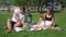 Young Family of Four Having Picnic in City Park