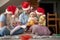 Young family gathered for christmas, sitting on the floor at home, enjoying together. baby looking at camera