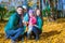 Young family with litlle girls in autumn park on