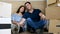 Young family lying on the floor after moving all the cardboard boxes in new house