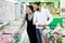 A young family, a man and a woman choose meat in a large supermarket.