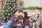 Young family man and woman kissing small kid in merry christmas