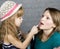 Young family mother and daughter make up at mirror