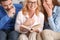 Young family with mother-in-law at home weekend laughing at story close-up