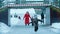 A young family of mother and two little children skating on the ice