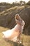 A young family in nature in identical dresses. beautiful young mom holds her daughter in her arms. Field and hills background