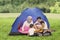 Young family plays a guitar in the campground