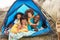 Young Family Relaxing Inside Tent On Holiday