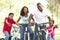 Young Family Riding Bikes In Park