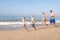 Young family running on beach