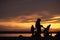 Young family silhouetted against an ocean sunset