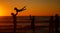 A young family silhouetted on the beach while playing together. Cheerful family with one child, two parents and daughter