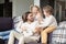 Young family sitting on couch in living room at home