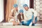 Young family sitting on floor. in a winter sweater and hat, the concept of Christmas. pregnancy in a wooden house