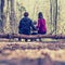 Young family sitting on a tree trunk