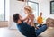 Young family with small child indoors in bedroom having fun.