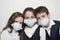 Young family of three little kids in medical masks and school uniform during coronavirus COVID-19 epidemy quarantine