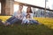 Young family with two daughters sitting on lawn, close up