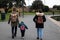 A young family walking together wearing backpacks