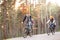 Young family in warm clothes cycling in autumn park