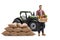 Young farmer carrying a crate with vegetables and posing in front of a tractor and a pile of sacks