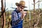 Young farmer checking blossom in orchard.